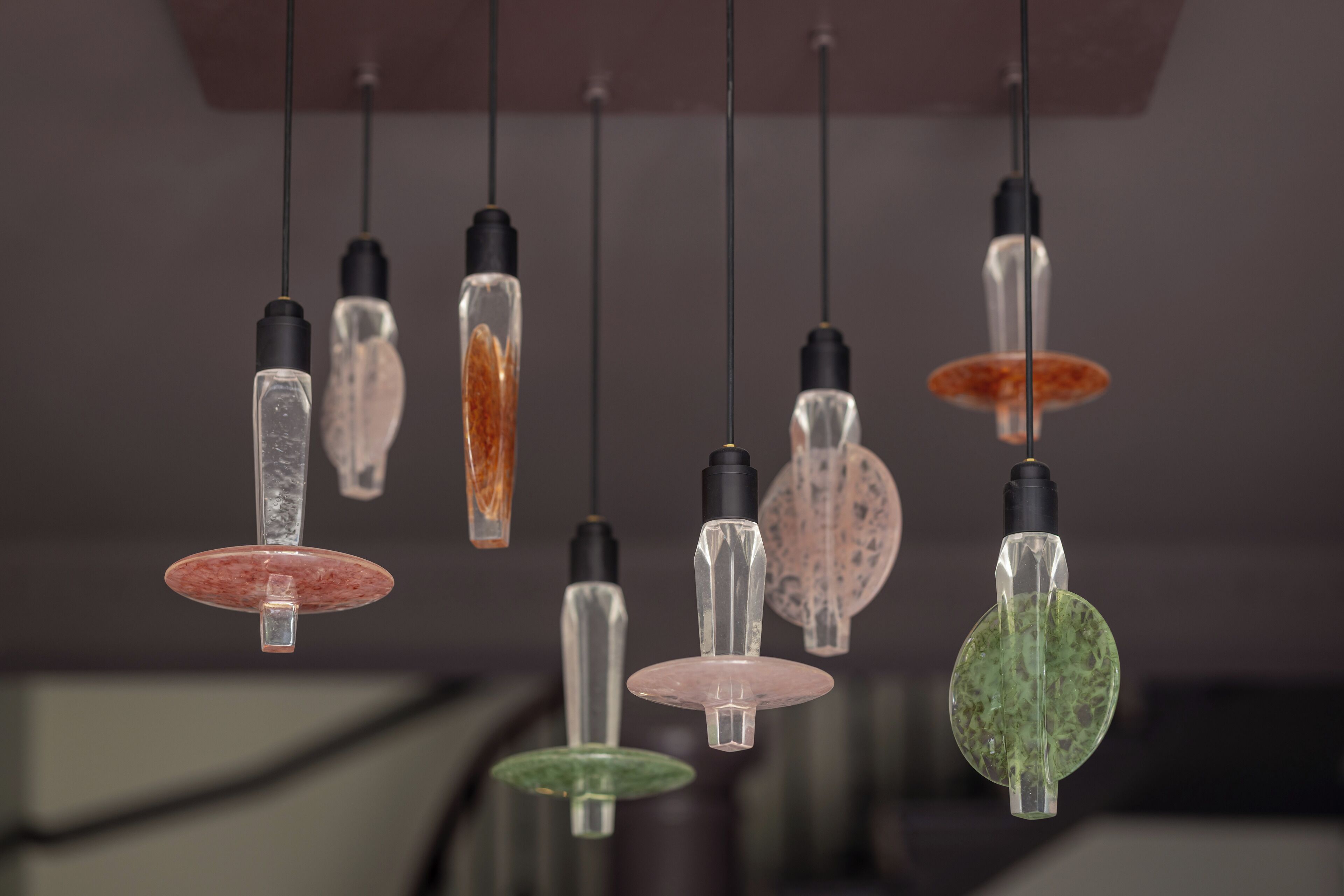 A series of pendant lights with clear glass shades and black bases.