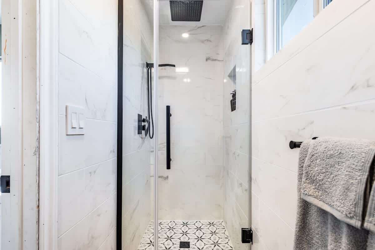 Chuveiro, secador de cabelo, toalhas de banho, shampoo