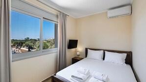 A hotel room with a bed, a TV, a nightstand, and a window with curtains. - Charming Villa Penelope with Private Pool walking distance to Lefkada town (Lefkada)