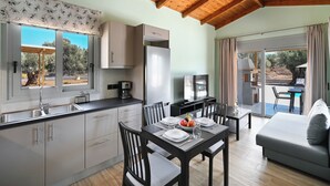 Eine moderne Küche mit Essbereich, Fernseher und Blick ins Freie.