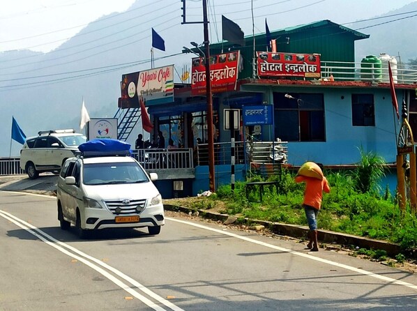 Ein Gebäude mit einem Schild für 'Yaari Cafe' und 'Hotel Indralok'.