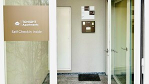 A self-checkin kiosk and elevator signage in a building. - TONIGHT Apartments (Bottmingen)