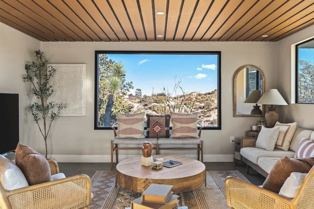 A living room with a large window, a round coffee table, and a sofa.