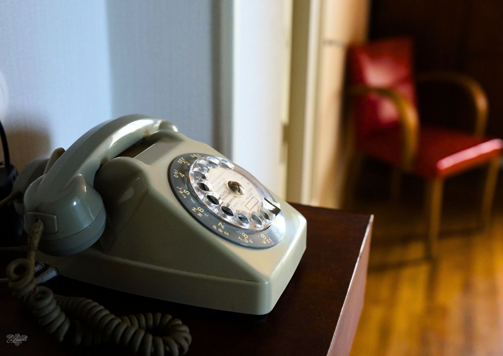 Un teléfono antiguo de disco giratorio sobre una mesa de madera.