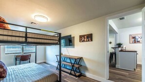 A compact room with a bunk bed, a desk, and a small kitchenette. - The Azure Escape Summ (Corpus Christi)