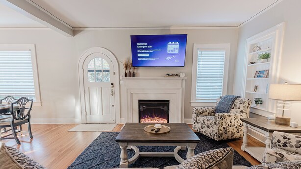 A modern living room with a fireplace, a flat-screen TV, and comfortable seating. - Park House - a Blackhouse Property (Tallahassee)