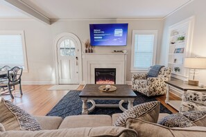 A modern living room with a fireplace, a flat-screen TV, and comfortable seating. - Park House - a Blackhouse Property (Tallahassee)