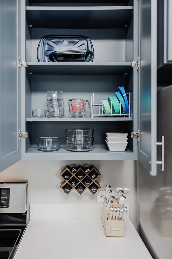 A kitchen with a built-in cabinet containing glassware, plates, and a knife block. - Park House - a Blackhouse Property (Tallahassee)