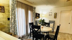A dining area with a round table, black chairs, a potted plant, and a patterned sofa. - 3-Bdrm Home on Large Property at Norris Lake. Pet Friendly! (New Tazewell)