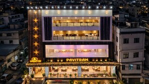 A multi-story building with a prominent 'PAVITRAM' sign, featuring a modern design with balconies and a well-lit facade. - Pavitram Hotel & Banquet (Ranchi)
