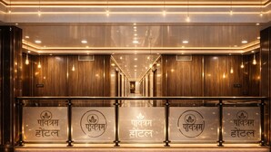 A hotel entrance with a modern design, featuring a marble floor and wooden paneling. - Pavitram Hotel & Banquet (Ranchi)