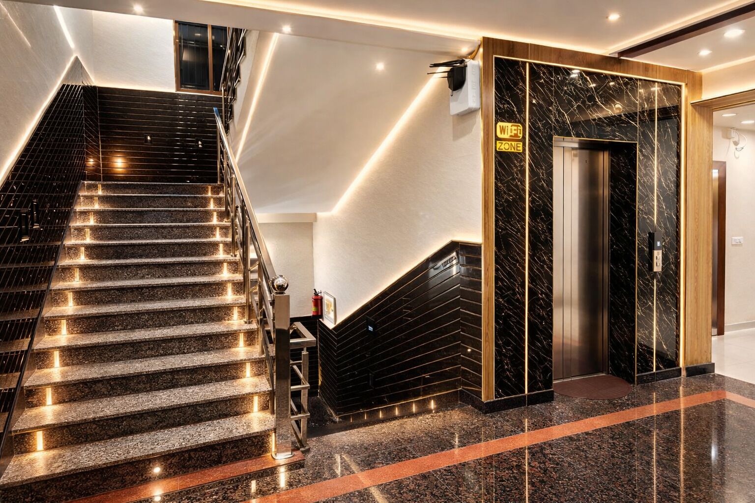 En modern hotellobby med en trappa i marmor, en skylt som visar var det finns Wi-Fi och en hiss.