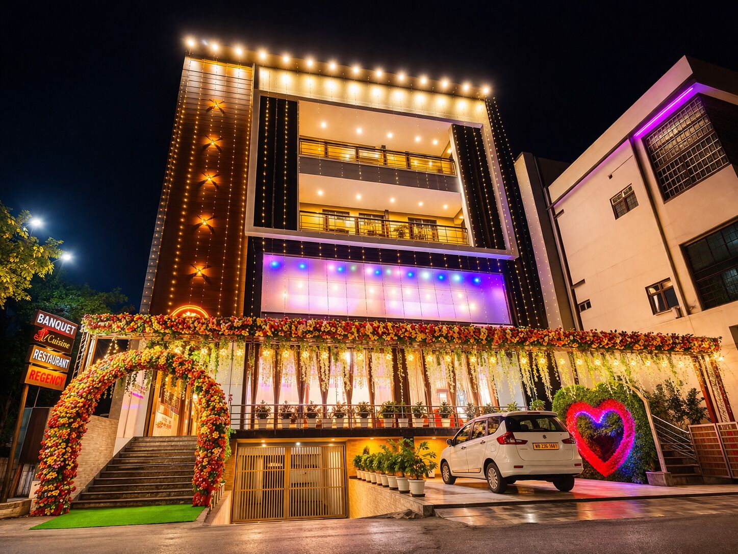 A multi-story building with a balcony, a signboard, and a car parked in front.