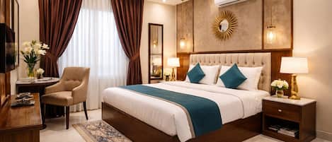 A hotel room with a large bed, a desk, a chair, a nightstand, and a wall-mounted air conditioner.