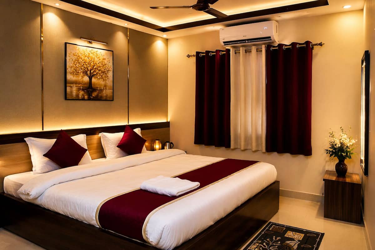 Una habitación de hotel moderna con una cama grande, un ventilador de techo, un equipo de aire acondicionado, una mesita de noche con una lámpara y un cuadro en la pared.