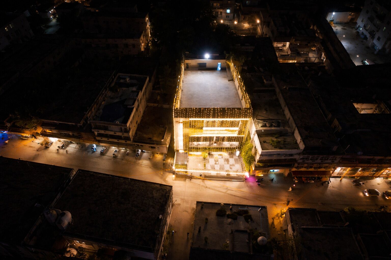 An aerial view of a building with a central courtyard, surrounded by other structures.