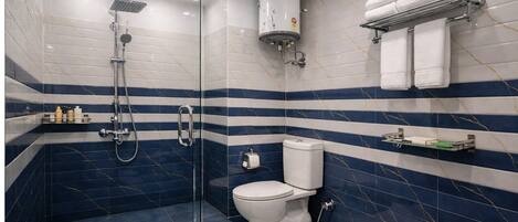 A modern bathroom with a glass-enclosed shower, a toilet, and a towel rack.