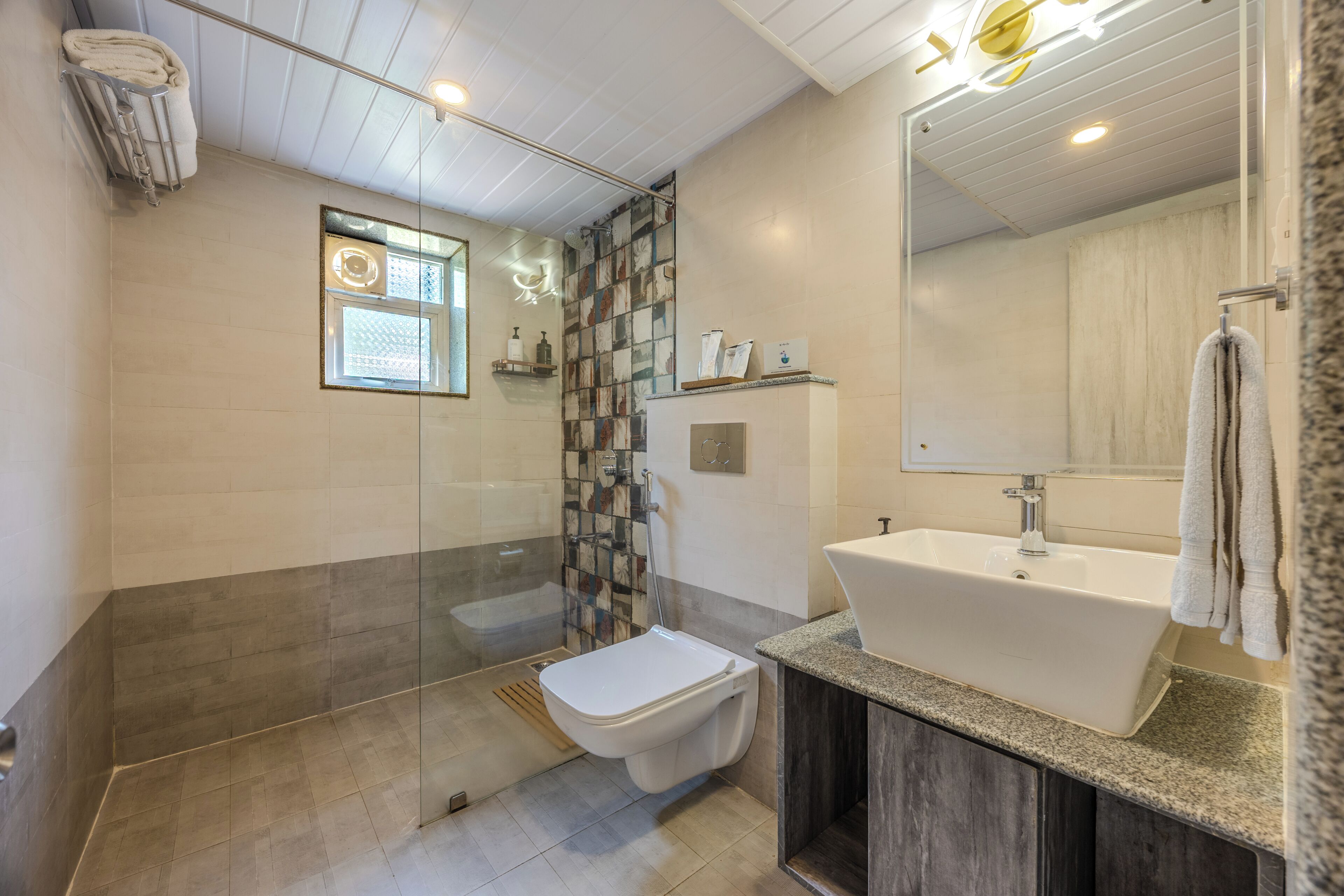 Une salle de bain moderne équipée d’une douche, de toilettes et d’un lavabo.