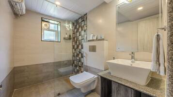 Une salle de bain moderne équipée d’une douche, de toilettes et d’un lavabo.
