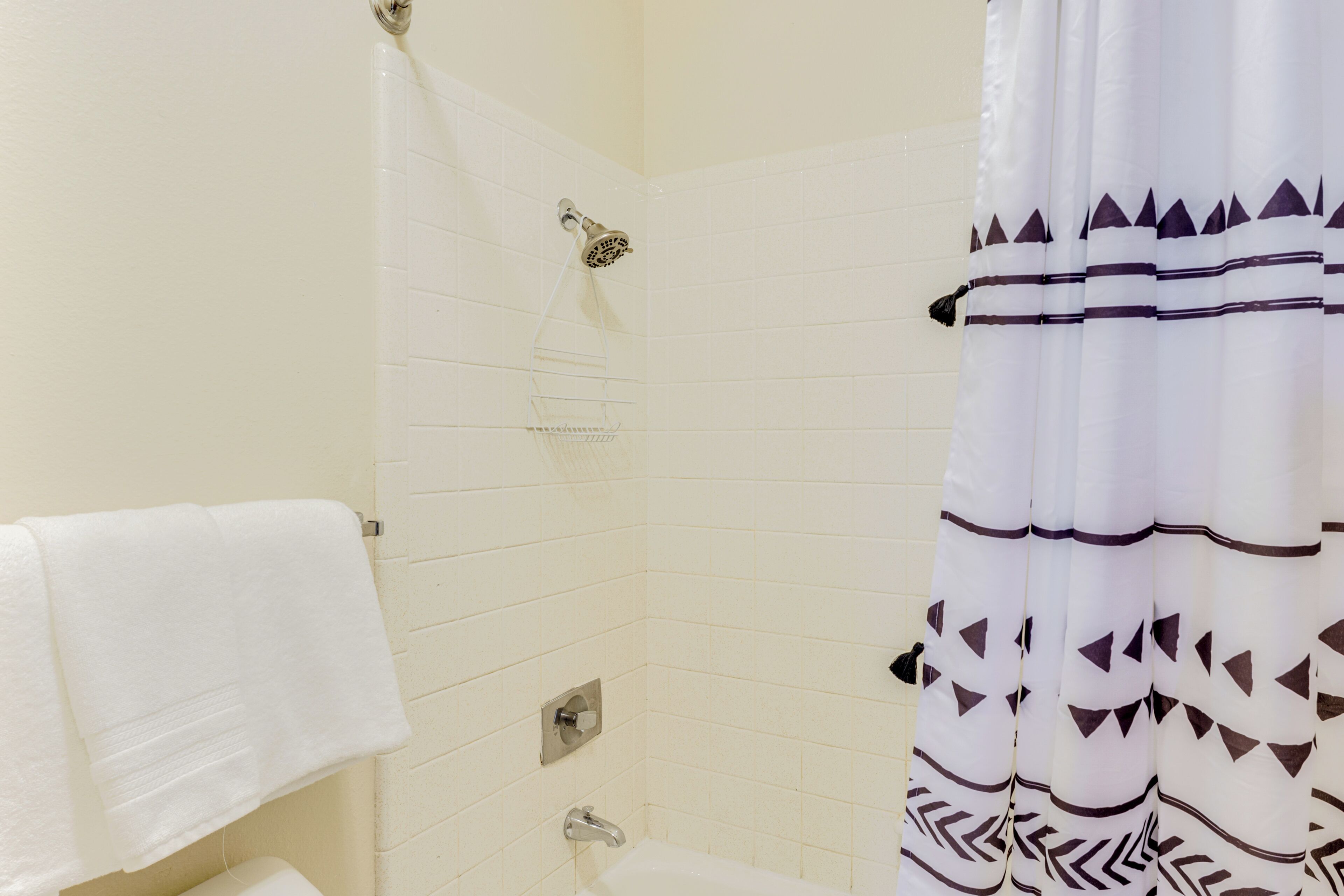 Ein Badezimmer mit Dusche, Toilette und Handtuchhalter.