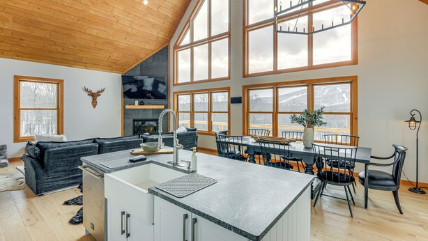Una cocina amplia con una isla central, ventanas grandes y un techo alto.