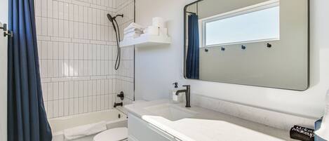 A bathroom with a bathtub, toilet, and sink.