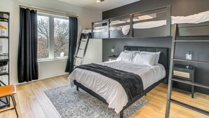 Un dormitorio moderno con una cama litera, un escritorio y una escalera.