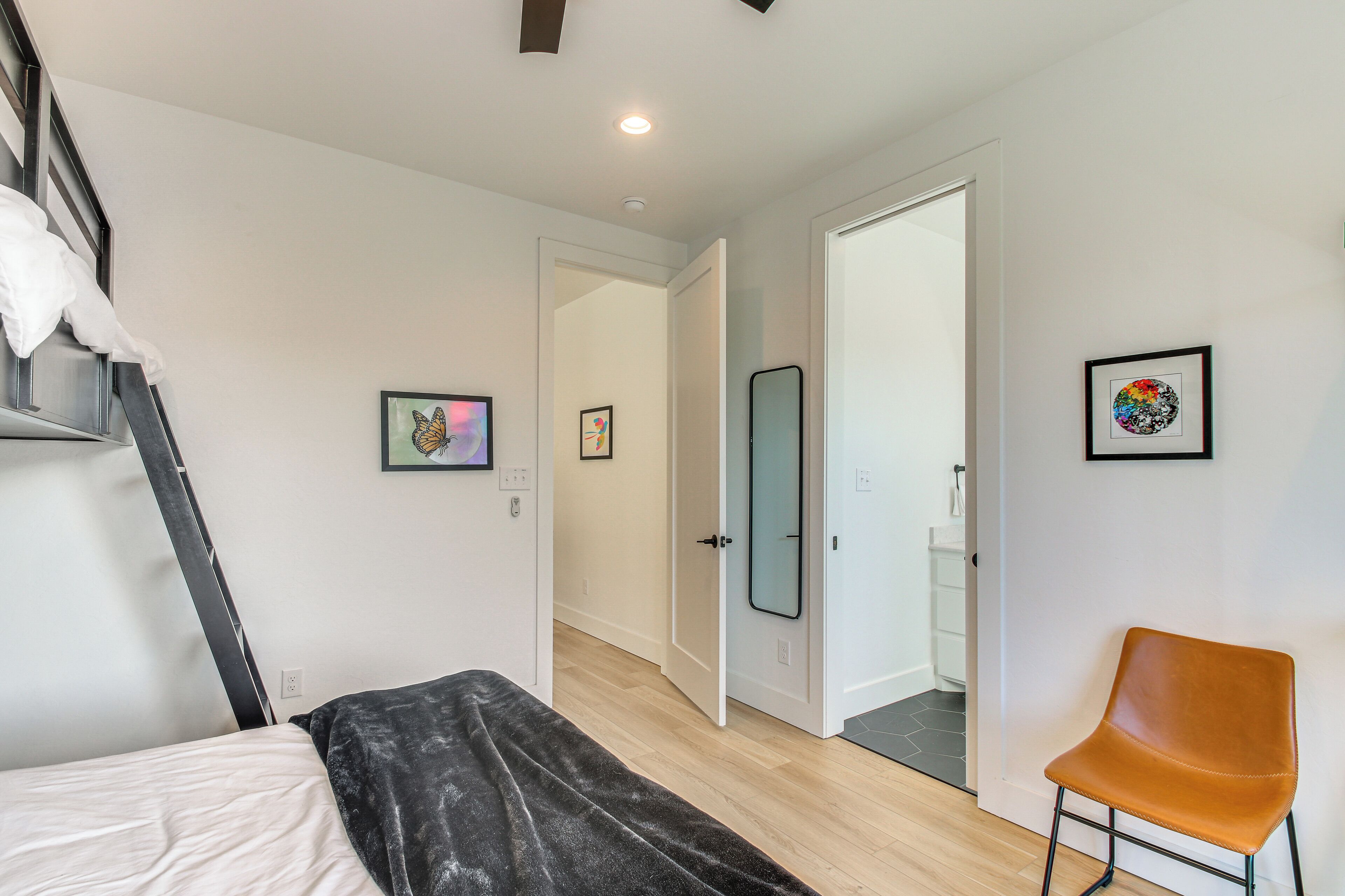 Une chambre à coucher comprenant un lit, une chaise et une porte donnant sur une autre pièce.