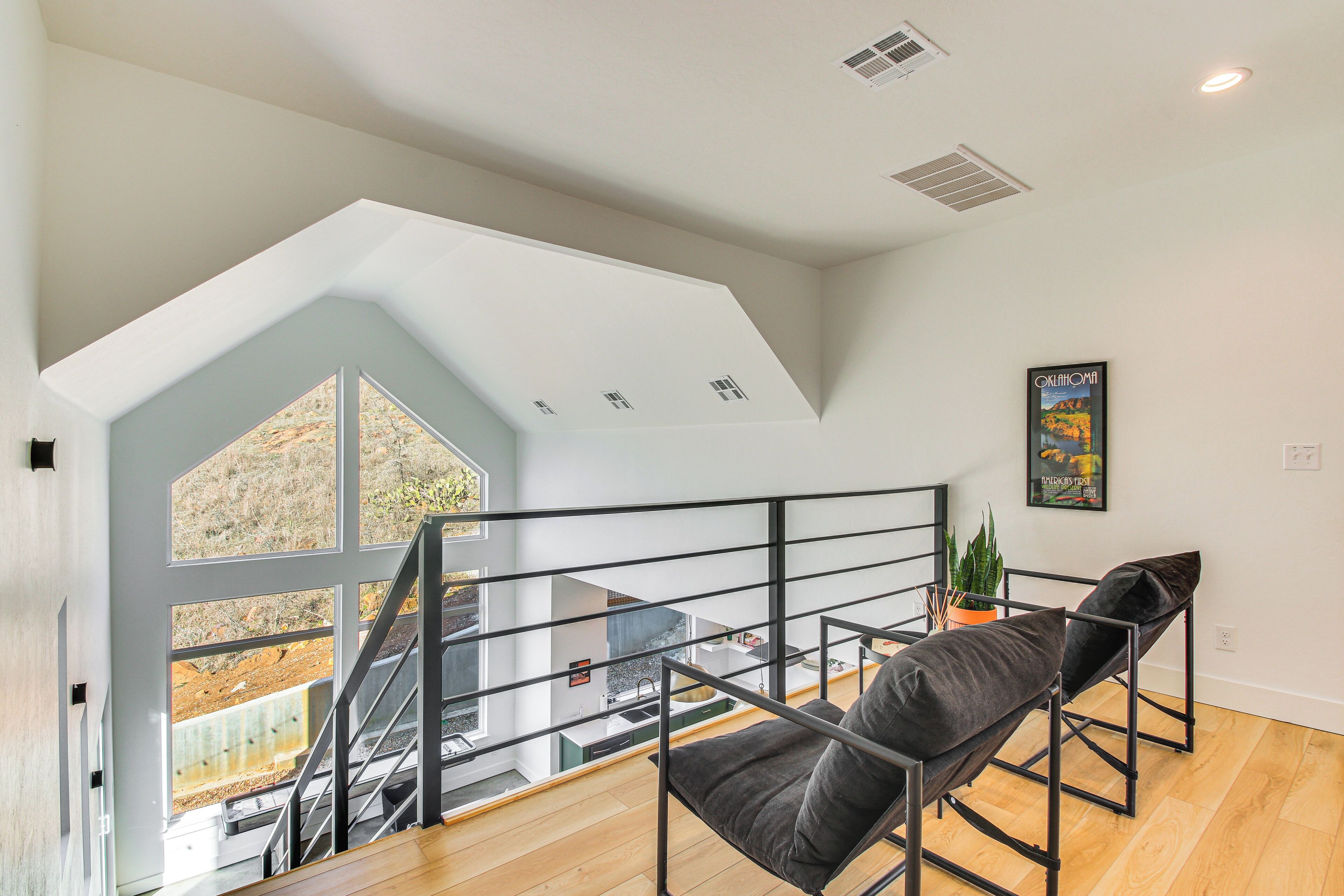 Un vaste loft doté d’un plafond haut, d’une mezzanine et offrant une vue sur une cascade.