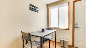 Un espace repas comprenant une table, des chaises et un panneau indiquant : « ESPACE JEUX – NE PAS DÉRANGER ».