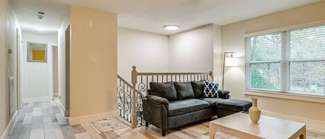 A living room with a gray sofa, wooden coffee table, and a ceiling fan.