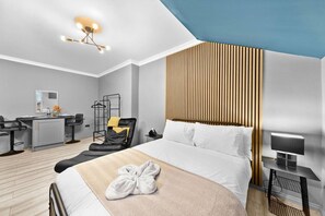 A modern hotel room with a bed, a desk, a chair, and a hanging light fixture. - Downtown Studio 3 | Harrogate Town Centre (North Yorkshire)