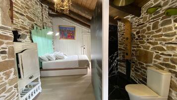Una camera da letto con un letto, un lampadario e un quadro appeso al muro.