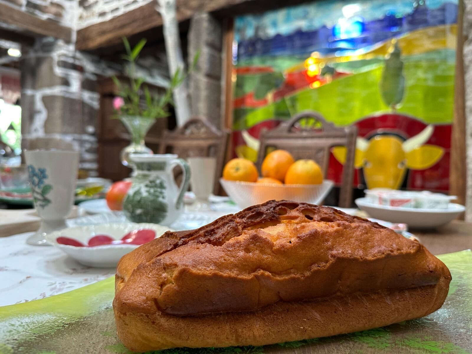 A loaf of bread on a table with a colorful mural in the background.