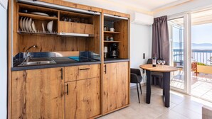 Una cocina moderna con armarios de madera, estufa integrada y una zona de comedor con mesa y sillas.