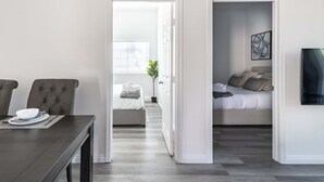 A modern room with a dining table, a bed, and a small balcony. - Elegant Retreat Modern Comforts Prime Location (Rosemead)