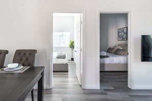 Ein modernes Zimmer mit Esstisch, Bett und kleinem Balkon.
