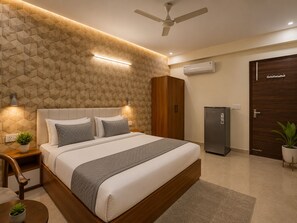 Ein modernes Schlafzimmer mit Wand in geometrischem Muster, einem Bett mit Kopfteil, Nachttischen mit Lampen, einem Deckenventilator, einer Klimaanlage, einem Kleiderschrank und einem Kühlschrank.