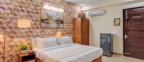 A bedroom with a bed, a nightstand, a lamp, a wardrobe, a ceiling fan, an air conditioner, and a door.