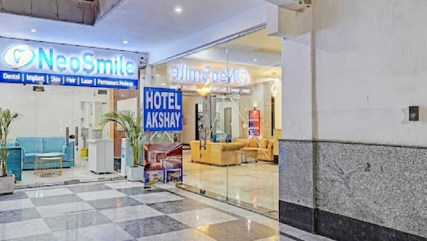 A hotel interior with a checkered floor, a reception desk, and a sign for 'Hotel Akshay'. - Hotel Akshay (Gurugram)