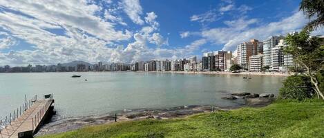 Un paisaje urbano costero con un puerto deportivo, un muelle y edificios altos.