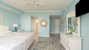 A bedroom with a bed, a dresser, a mirror, a ceiling fan, and a television. - Jetty's Break-Beautiful 3 Bedroom Condo steps from the beach! (Ocean City)