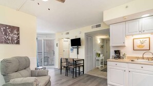 A compact living space with a sofa, dining table, and kitchen area. - Luxury Beachfront Resort Condo (Myrtle Beach)