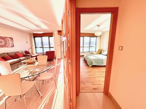 A modern living room with a glass coffee table, a sofa, and a dining area with chairs. - The Cliffs - Galician Blue Views (Ortigueira)