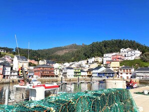 Un pueblo costero con un puerto deportivo, barcos y redes de pesca.