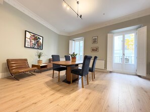 Enjoy meals at the dining table surrounded by comfortable chairs, with a beautiful view through the window.