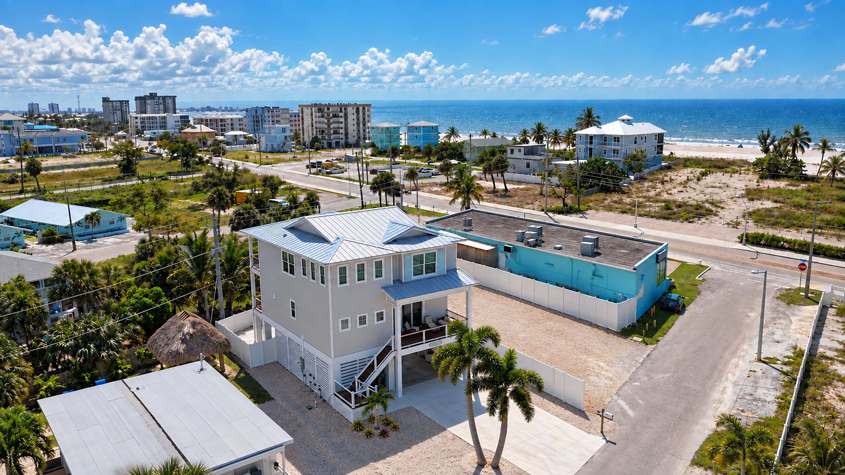 A coastal property with a large building, a swimming pool, and a beach view.