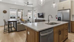 A modern kitchen with a large island, stainless steel appliances, and pendant lighting. - Villa #12 At Bloomington Country Club 4 Bedroom Townhouse (St. George)