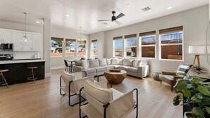 A spacious living area with a large sofa, a coffee table, and a dining area with bar stools.