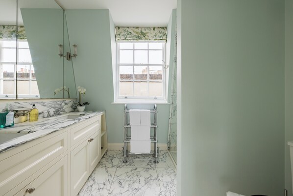 A bathroom with a marble countertop, a towel rack, and a window with a view of buildings. - The Chelsea Abode - 4bdr Home With Terrace (London)